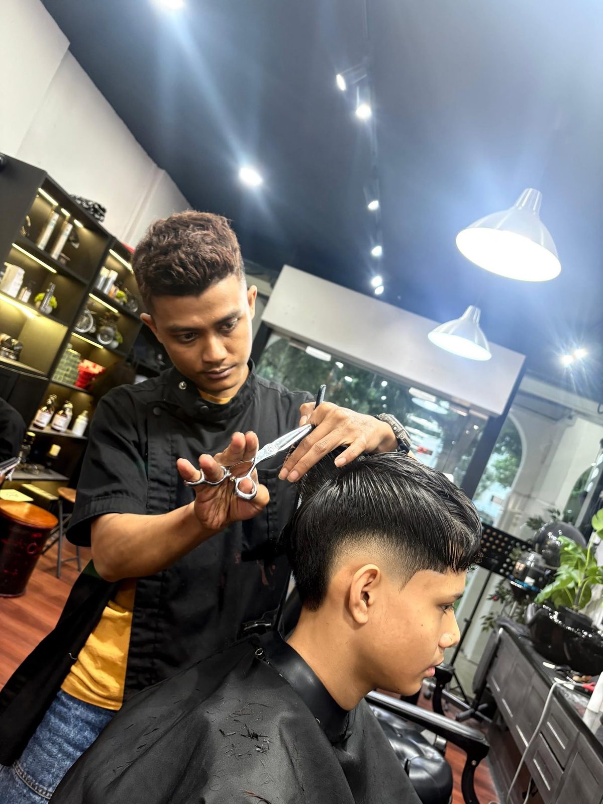 A barber working with scissors mid-cut